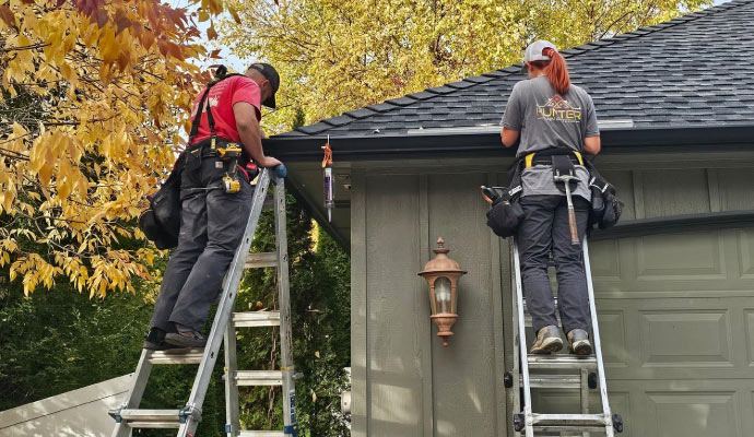 A1 Patios Gutters N More crew working at the roofline
