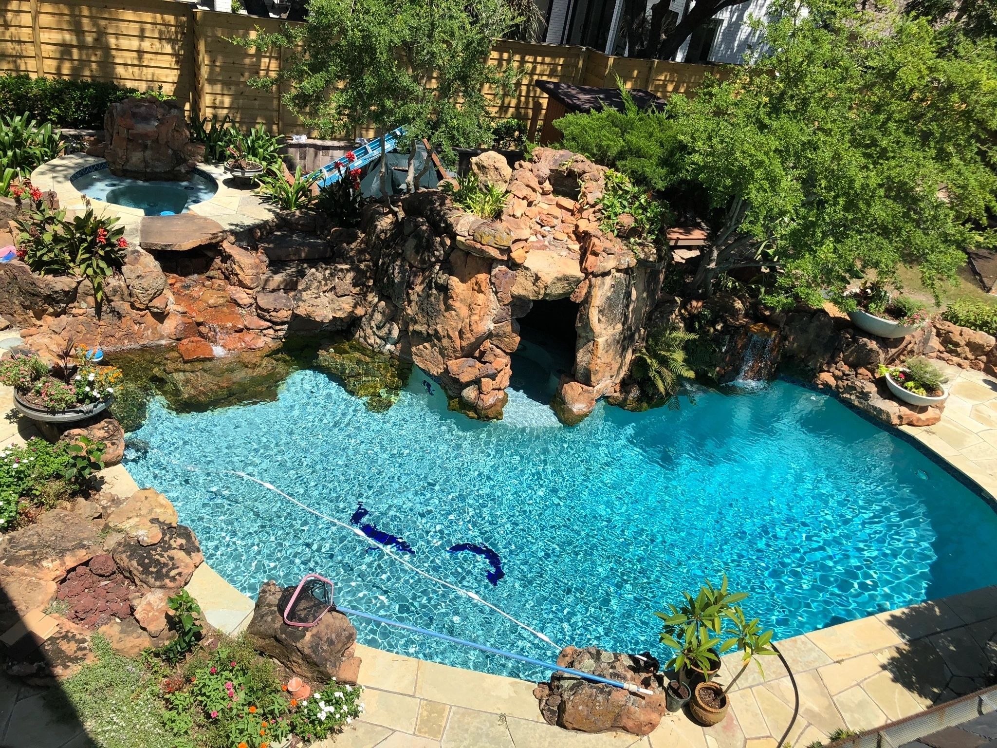 Backyard swimming pool with stone waterfall grotto