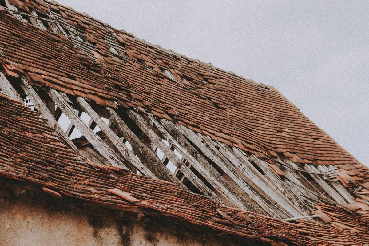 An aging roof with worn, broken decking