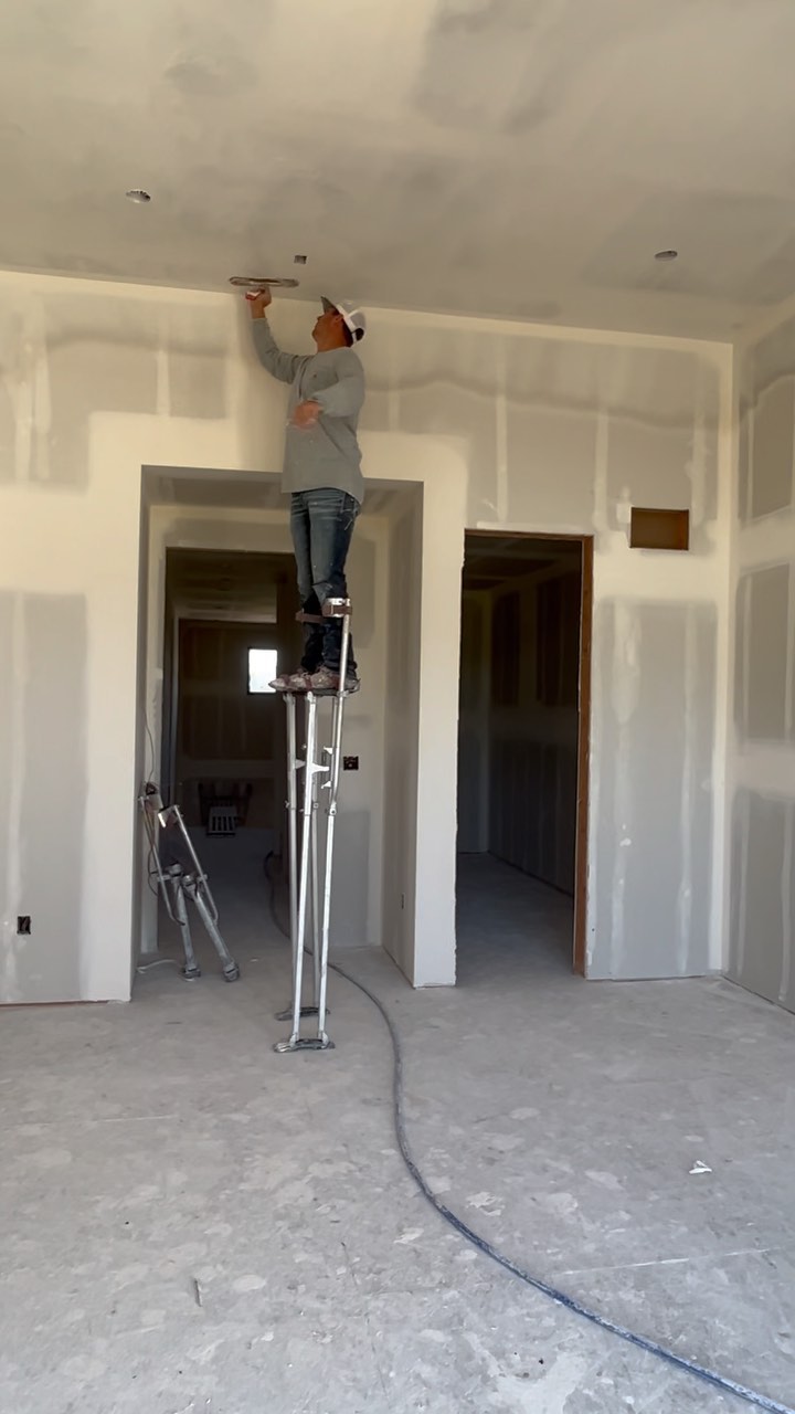 Bozeman Drywall crew finishing a high wall on stilts
