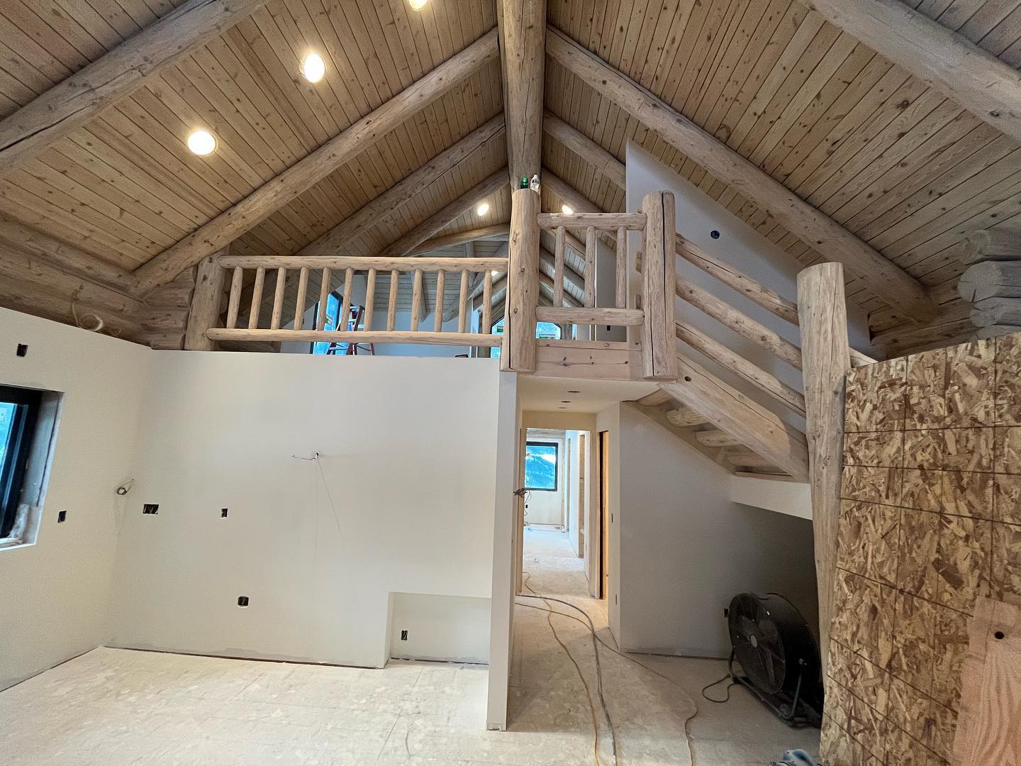 Large vaulted new-construction great room mid-drywall in the Gallatin Valley