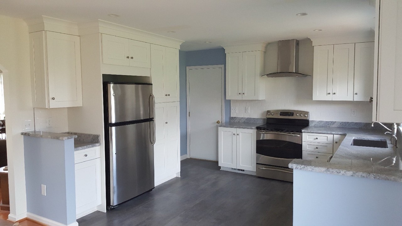 White kitchen remodel with stainless appliances and granite countertops