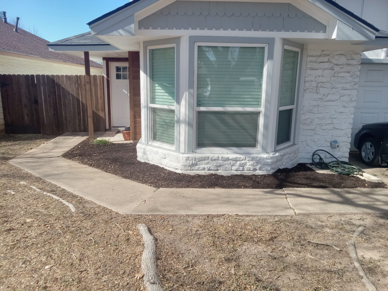 Fresh mulch bed installed along the front of a house