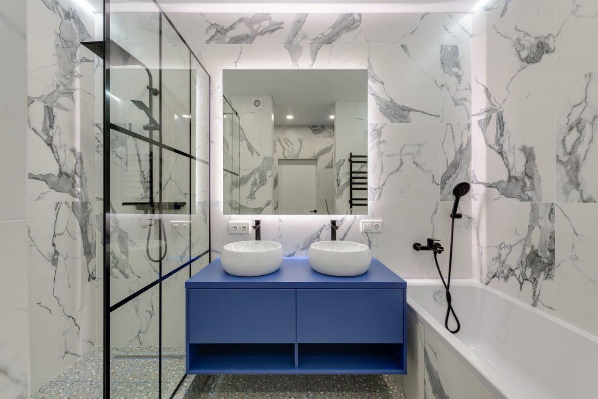 Bathroom with marble tile, a double vanity and a glass shower