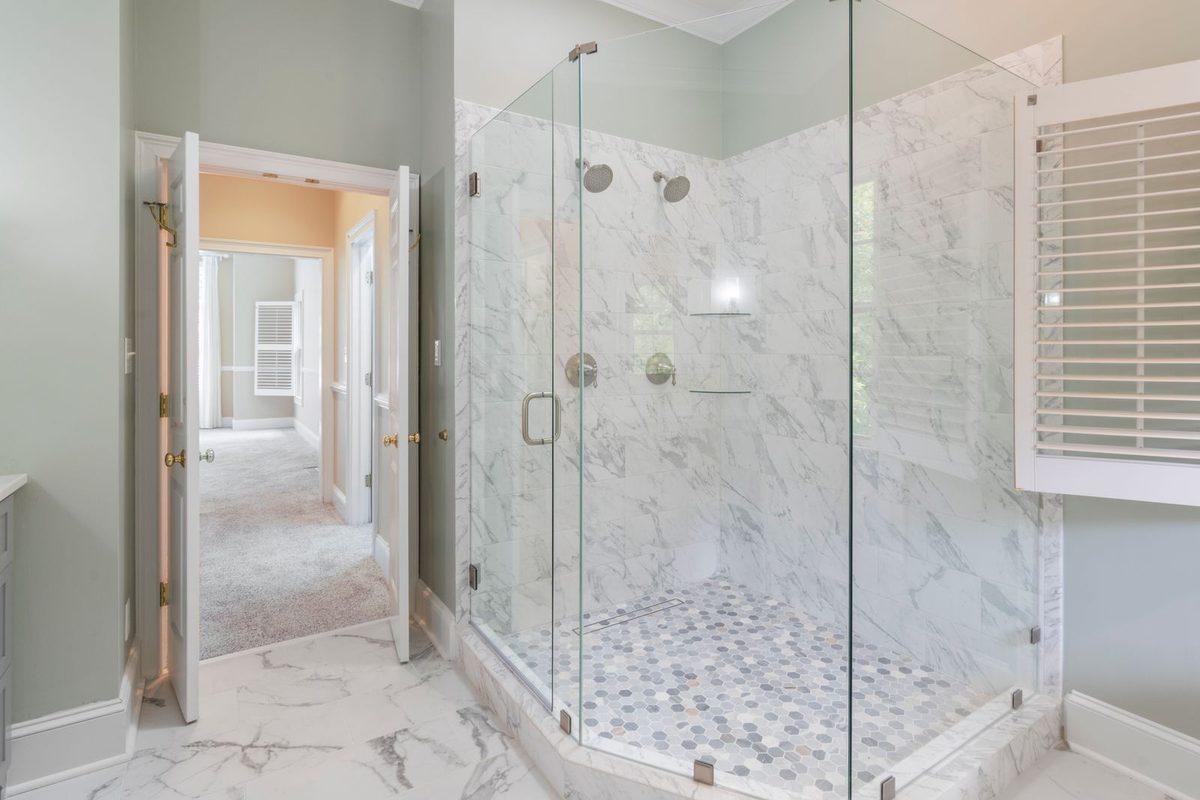 Finished bathroom with a tiled glass shower