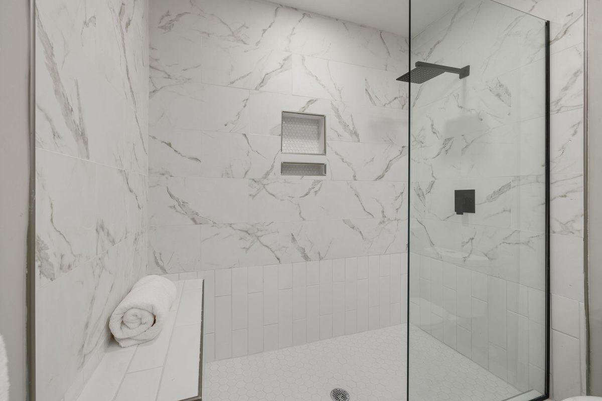 Tiled walk-in shower with a glass door