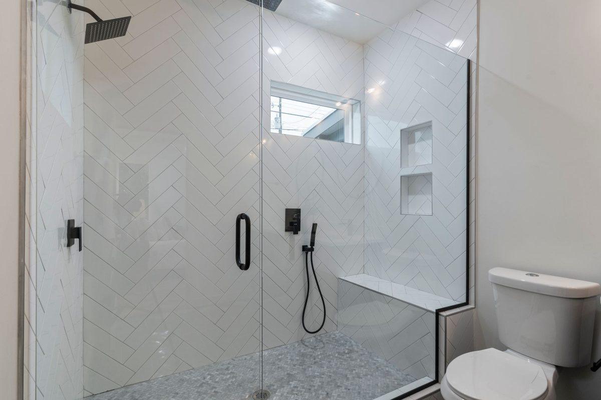 Tiled walk-in shower with matte black fixtures