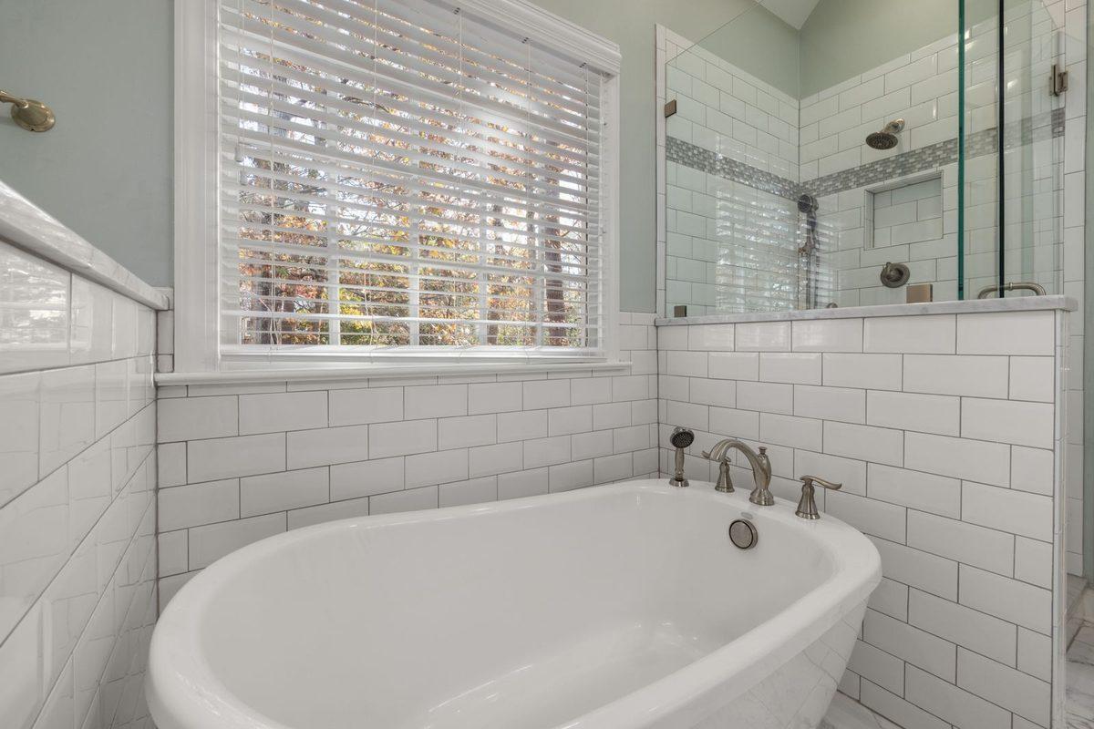 New white bathtub with a tiled surround