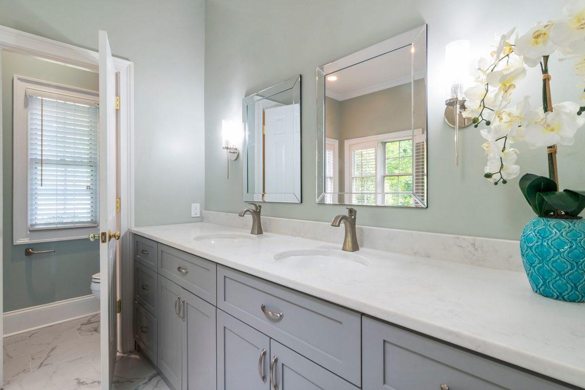 Double vanity with white countertop and mirrors in a finished bathroom