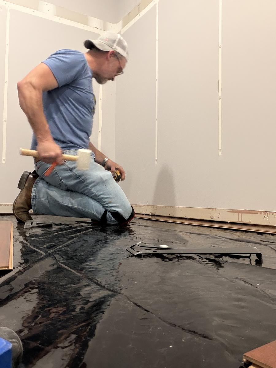 Here 2 Help Home Solutions team member installing flooring underlayment