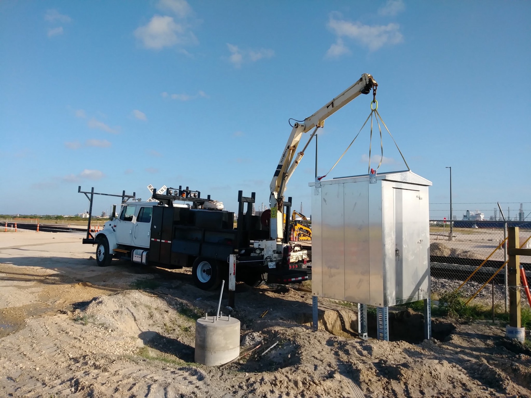 Signal cabinet being set with a service truck crane