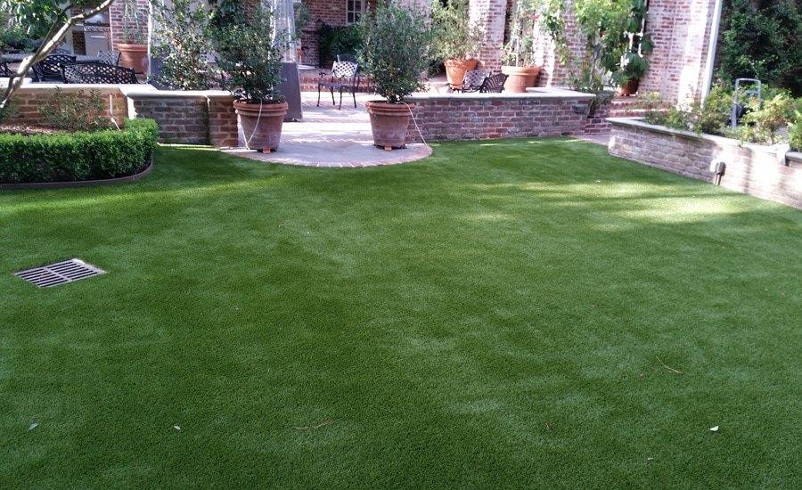 Artificial lawn beside a brick patio