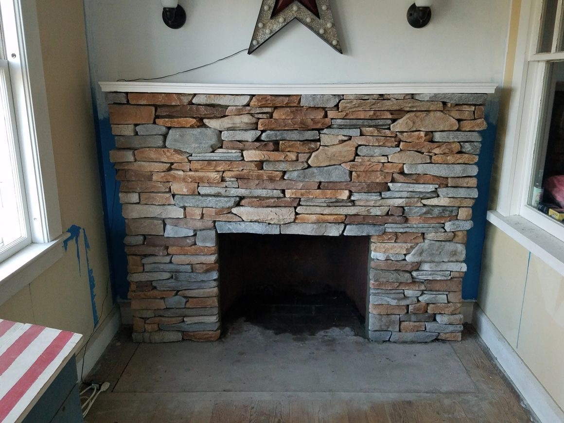 Mason spreading mortar along a brick course