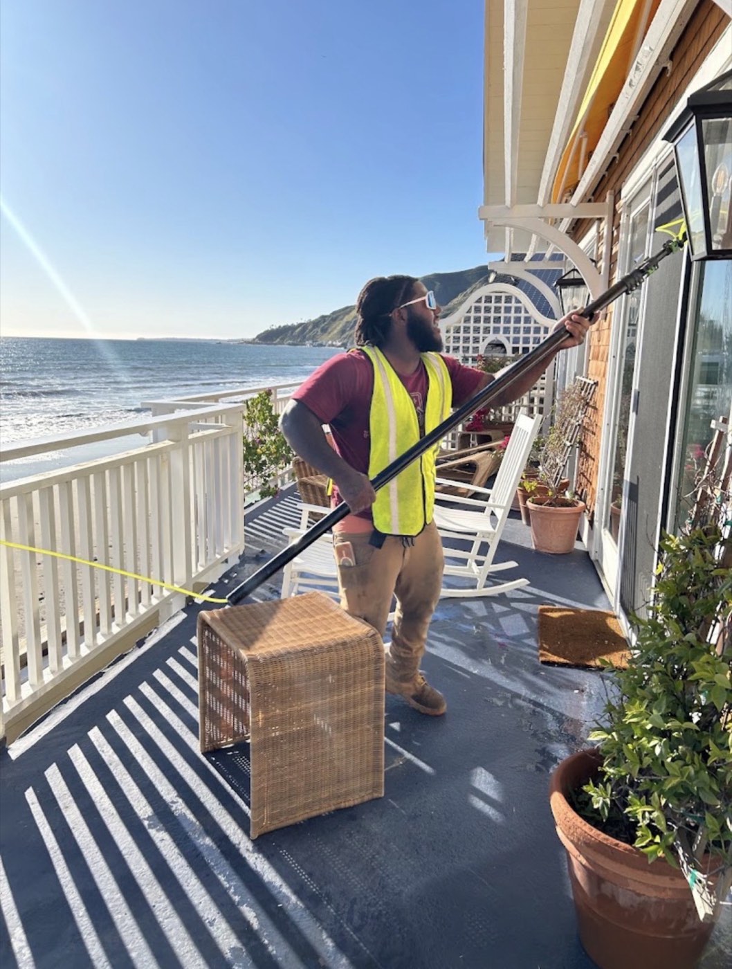 Technician cleaning windows on a home
