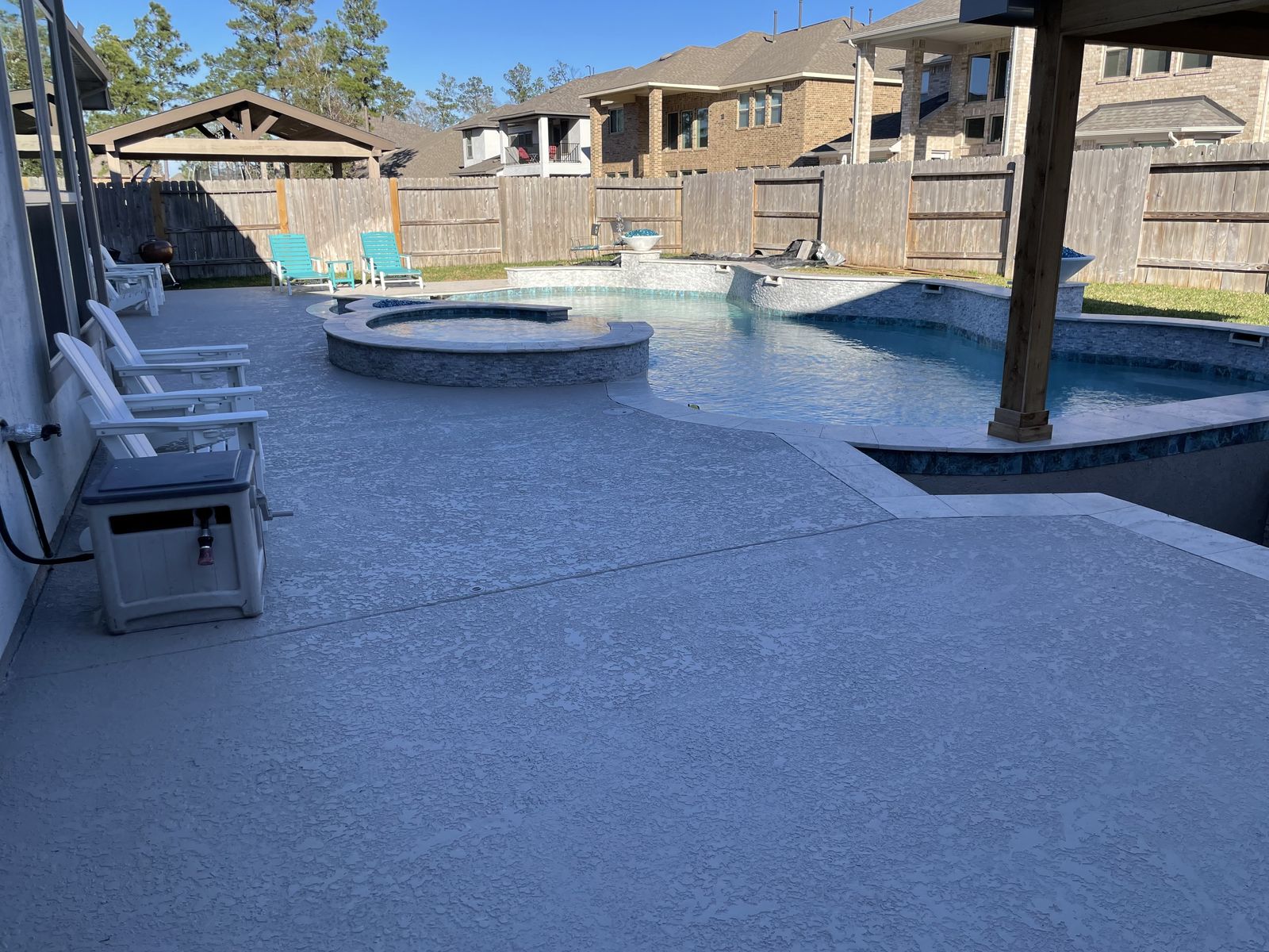 Pool deck and spa seen from under the pergola