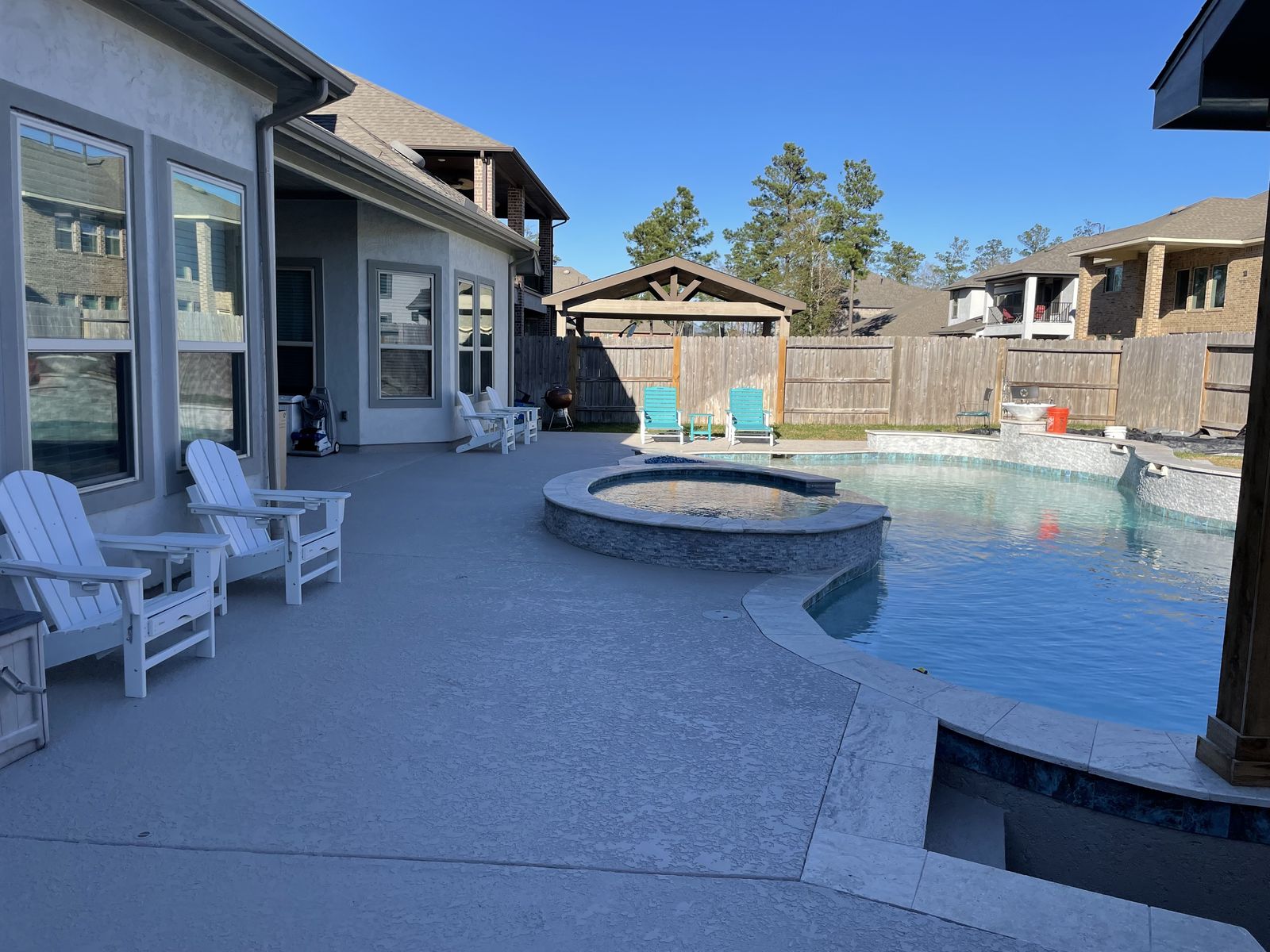 Pool deck with a raised spa and Adirondack chairs