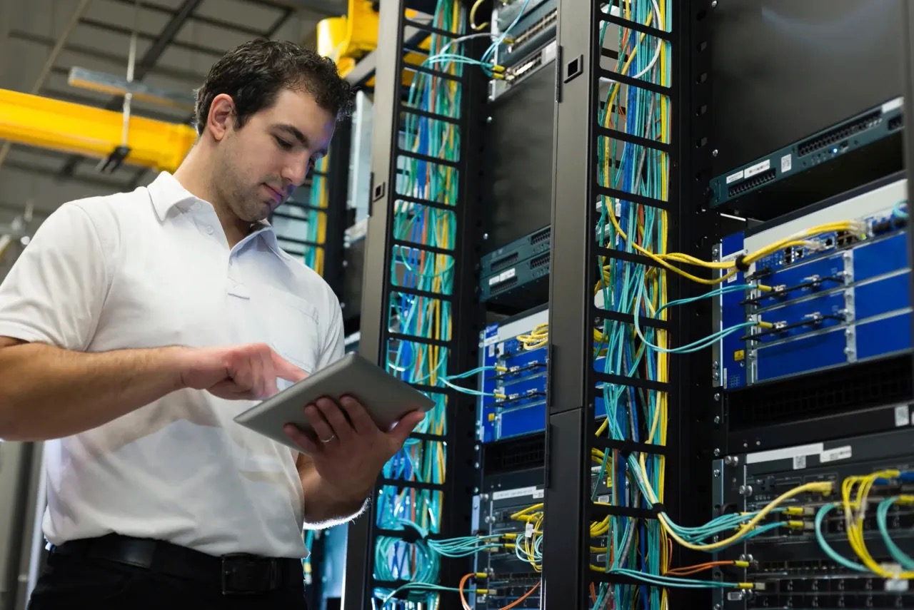 Technician reviewing a finished, organized network cabinet install